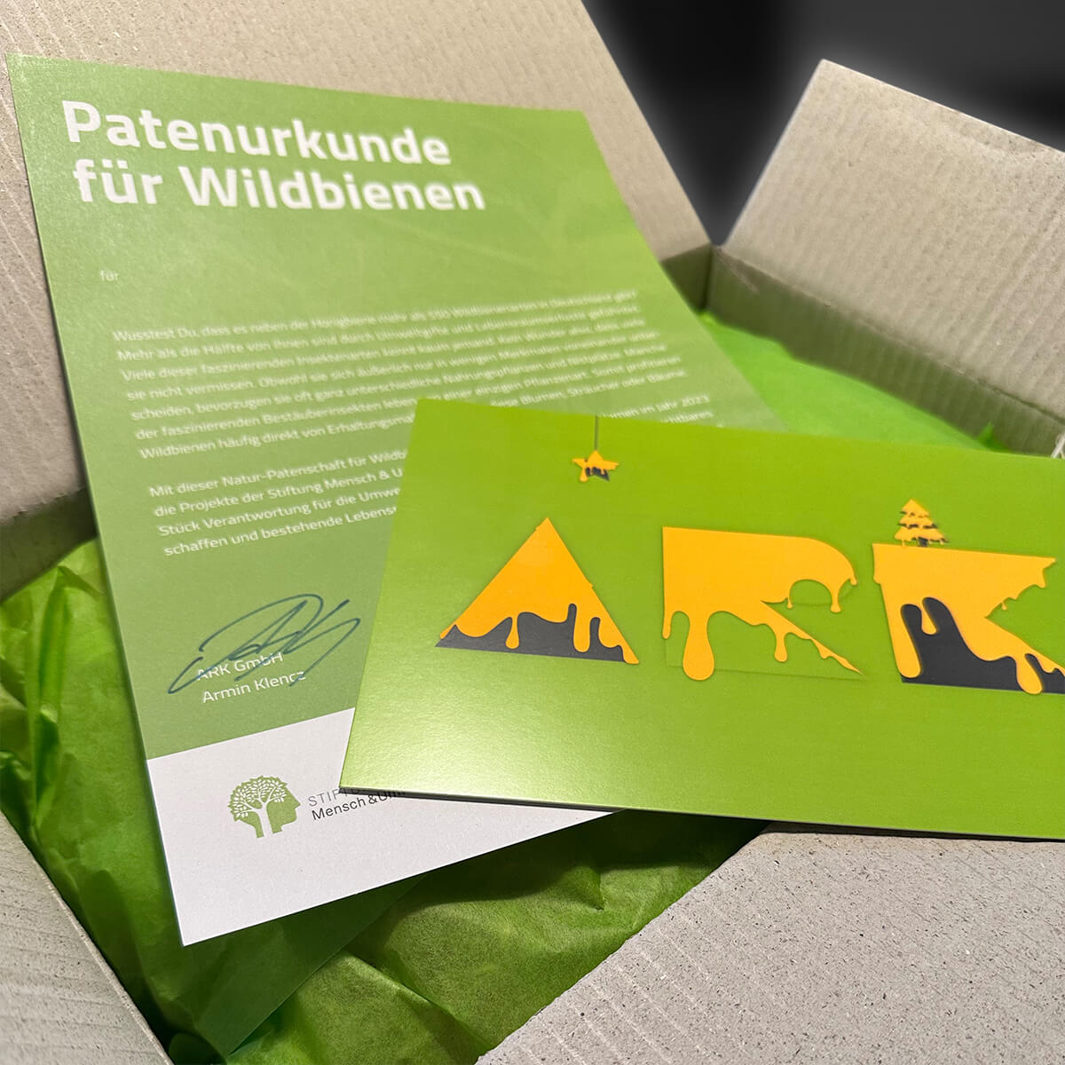 Hier sieht man eine Bienen-Partenurkunde und eine Grußkarte, bei der tikitay werbeagentur Gestaltung und Produktion übernommen hat.