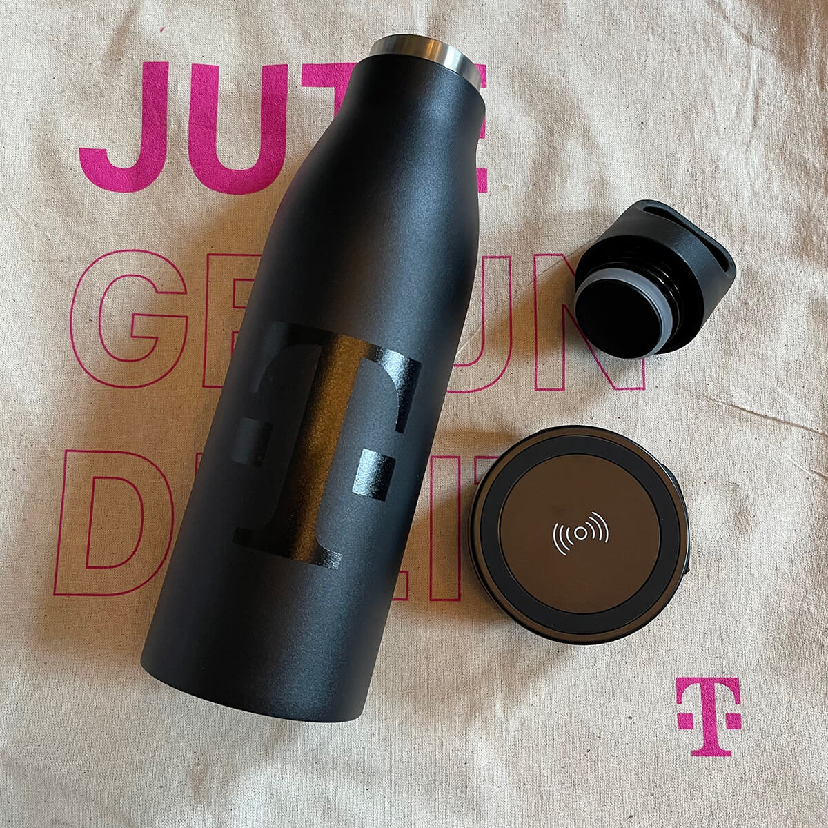 Hier sind zwei Giveaways (Jutebeutel und Trinkflasche mit integrierter Ladefunktion), die tikitay für die Deutsche Telekom produziert hat, zu sehen.